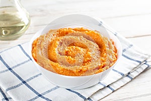 Roasted pumpkin hummus, creamy and delicious dip on a white plate on table