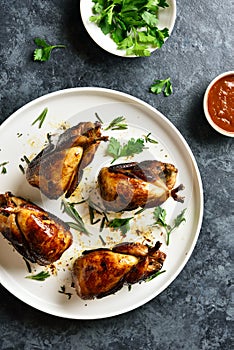 Roasted quails on white plate