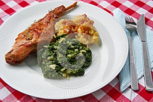 Roasted rabbit leg, marinated in garlic and rosemary served with spinach and potato dumplings