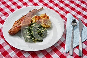 Roasted rabbit leg, marinated in garlic and rosemary served with spinach and potato dumplings