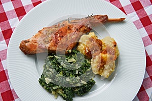 Roasted rabbit leg, marinated in garlic and rosemary served with spinach and potato dumplings