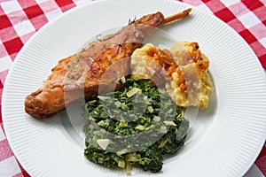 Roasted rabbit leg, marinated in garlic and rosemary served with spinach and potato dumplings