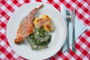 Roasted rabbit leg, marinated in garlic and rosemary served with spinach and potato dumplings