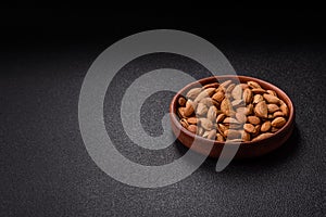 Roasted or raw almond nuts in shell in bowl