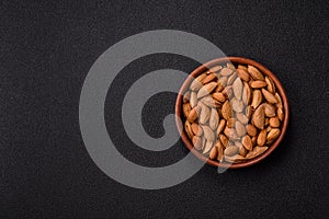 Roasted or raw almond nuts in shell in bowl