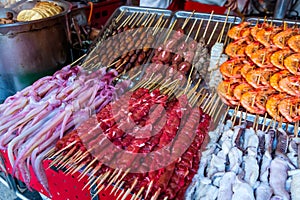 Roasted and raw insects, silkworms, scorpions, bugs, snakes, shrimps, dog meat, octopus on stick