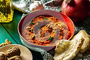 Roasted red bell pepper spread in a red bowl  with various ingredients