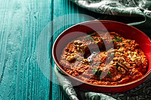 Roasted red bell pepper spread in a red bowl  with a vintage napkin