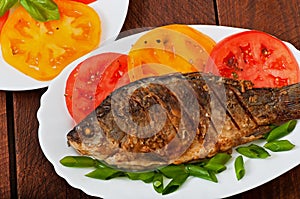 Roasted river fish carp on a white plate