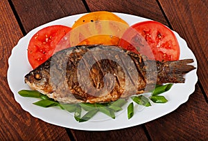 Roasted river fish carp on a white plate