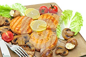 Roasted salmon medallions with mushrooms and vegetables closeup