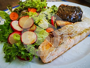 Roasted salmon on salad with radishes and carrots