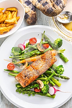 Roasted salmon steak with asparagos broccoli carrot tomatoes rad