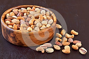 Roasted salted mixed nuts in wooden bowl. Closeup