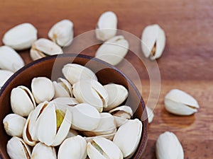 roasted and salted pistachios on wooden background