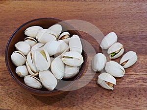 roasted and salted pistachios on wooden background