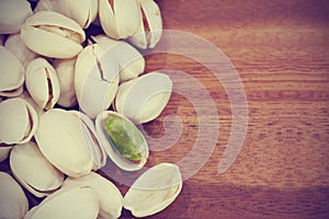 roasted and salted pistachios on wooden background