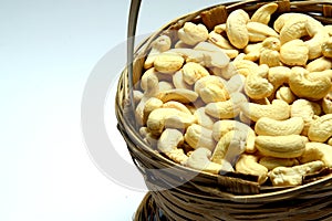 Roasted salted raw cashew nuts in wooden bowl on rustic table, healthy vegetarian snack, Anacardium occidentale, Cashews on white