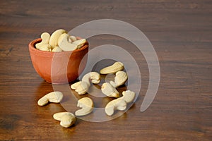 Roasted salted raw cashew nuts in wooden bowl on rustic table, healthy vegetarian snack, Anacardium occidentale, Cashews on white