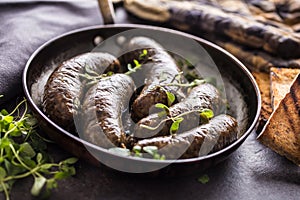 Roasted sausages in pan with bread and herbs.