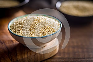 Roasted sesame seeds in bowl on wooden table