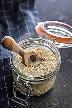 Roasted sesame seeds in jar on black table