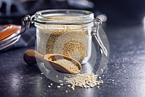 Roasted sesame seeds on scoop on black table