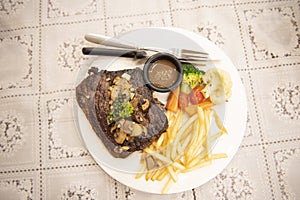 Roasted steak meat with vegetable herb spices black pepper corn and mushroom, grilled steak beef with french fries on plate on the