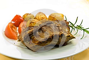 A roasted suckling pig with potatoes and salad