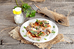 Roasted Turkey breast steaks with cheese and mushrooms on a plate