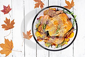 Roasted turkey garnished with cranberries on a rustic style table decorated  autumn leaf. Thanksgiving Day. Baked chicken. Top