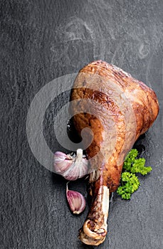 Roasted turkey leg on black stone background