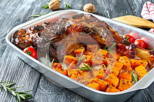 Roasted turkey leg and pumpkin pieces with aromatic herbs.