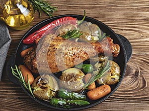 Roasted turkey leg with vegetables, carrots, peppers, potatoes vegetables in frying pan