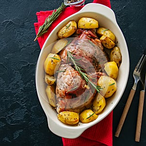 Roasted turkey with rozemary and potatoes in a dish on a black s photo