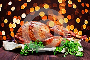 Roasted Turkey. Thanksgiving table served with turkey, decorated with greens and basil on dark wooden background. Homemade food