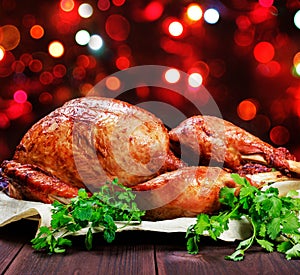 Roasted Turkey. Thanksgiving table served with turkey, decorated with greens and basil on dark wooden background. Homemade food