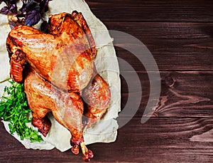 Roasted Turkey. Thanksgiving table served with turkey, decorated with greens and basil on dark wooden background. Homemade food