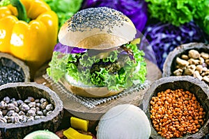 Roasted vegan hamburger, made of vegetables and proteins. Healthy and vegetarian life concept. Colorful food, peppers, red cabbage