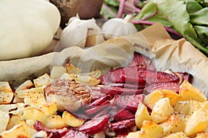 Roasted vegetables. Beetroot, pattypan squash, potatoes, garlic and onion. Fresh vegetables on background.