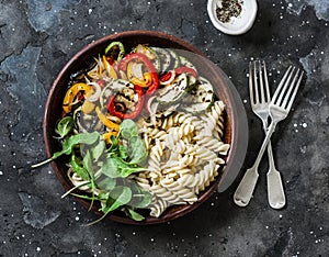 Roasted vegetables and fusilli pasta antipasti salad on dark background, top view