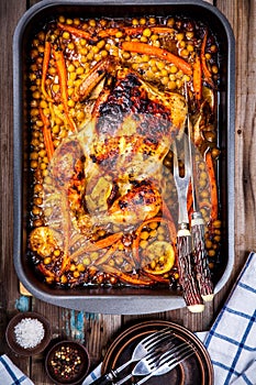 Roasted whole chicken with chickpeas, carrots and lemons