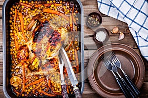 Roasted whole chicken with chickpeas, carrots and lemons