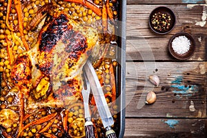 Roasted whole chicken with chickpeas, carrots and lemons