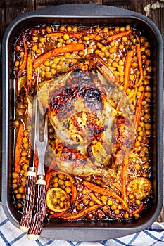 Roasted whole chicken with chickpeas, carrots and lemons