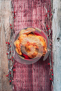 Roasted whole chicken with Christmas decoration on wooden background. Top view, copy space. Healthy diet concept