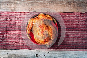 Roasted whole chicken with Christmas decoration on wooden background. Top view, copy space. Healthy diet concept