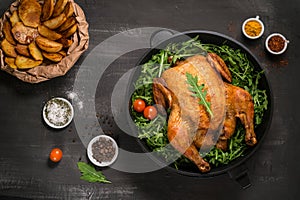 Roasted whole chicken or turkey served in iron pan Placed on black background