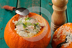 Roasted whole pumpkin with rice and meat with pepper mill