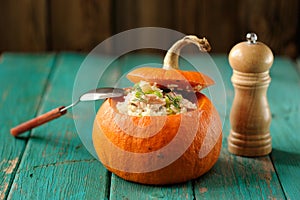 Roasted whole pumpkin with rice and meat with pepper mill select